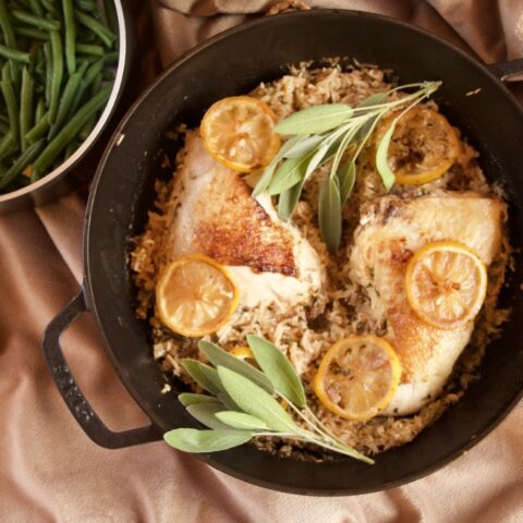 a skillet full of Meyer Lemon Chicken and Rice. A pan of sauteed green beans sits in the background.