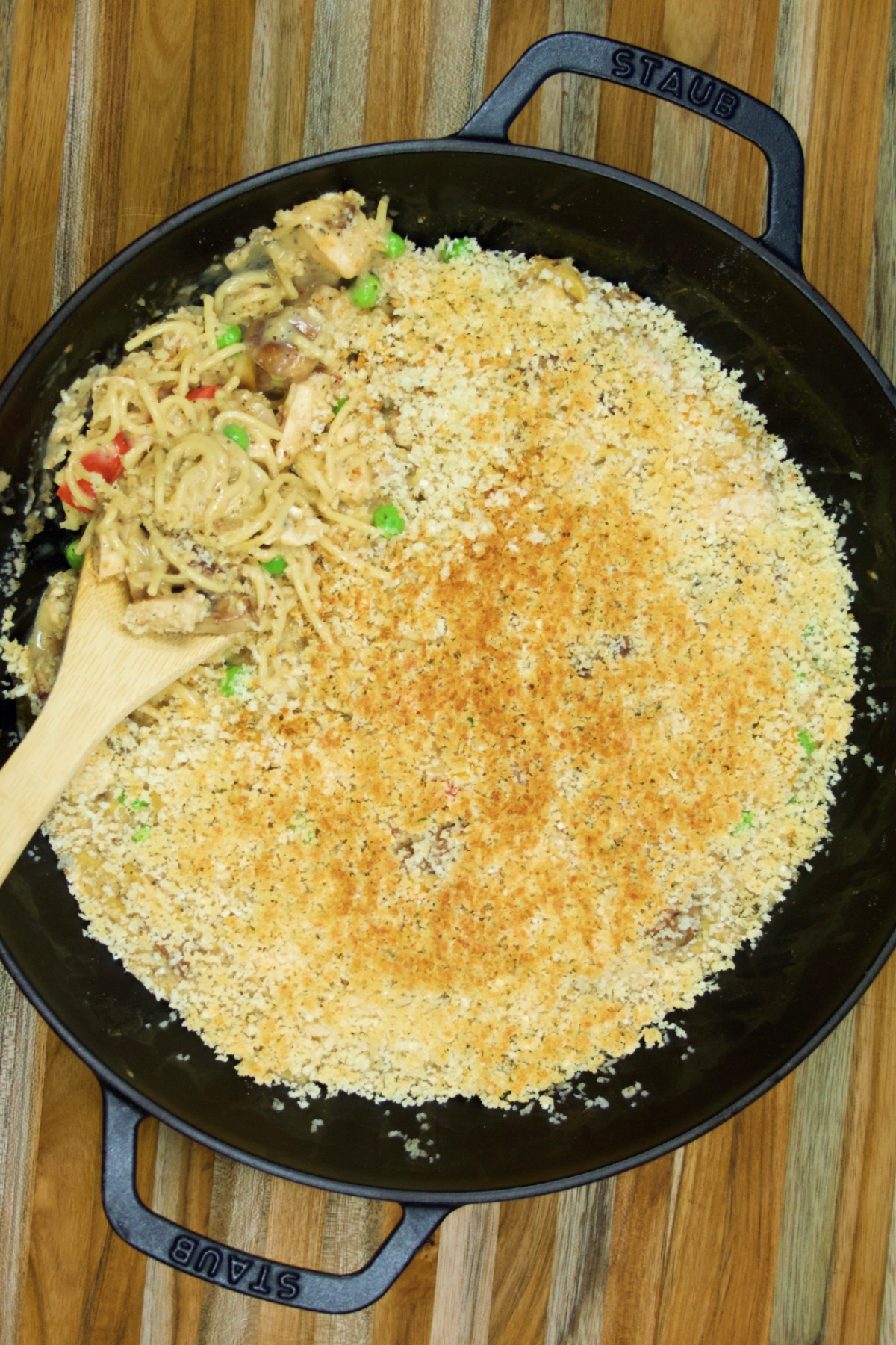 A pan of steaming hot turkey tetrazzini being served up. The breadrumb topping is toasted to golden-brown perfection.