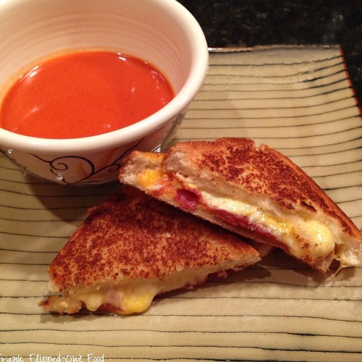 roasted tomato soup and grilled cheese sandwich on a stripey plate