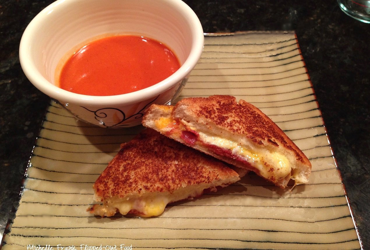 roasted tomato soup and grilled cheese sandwich on a stripey plate