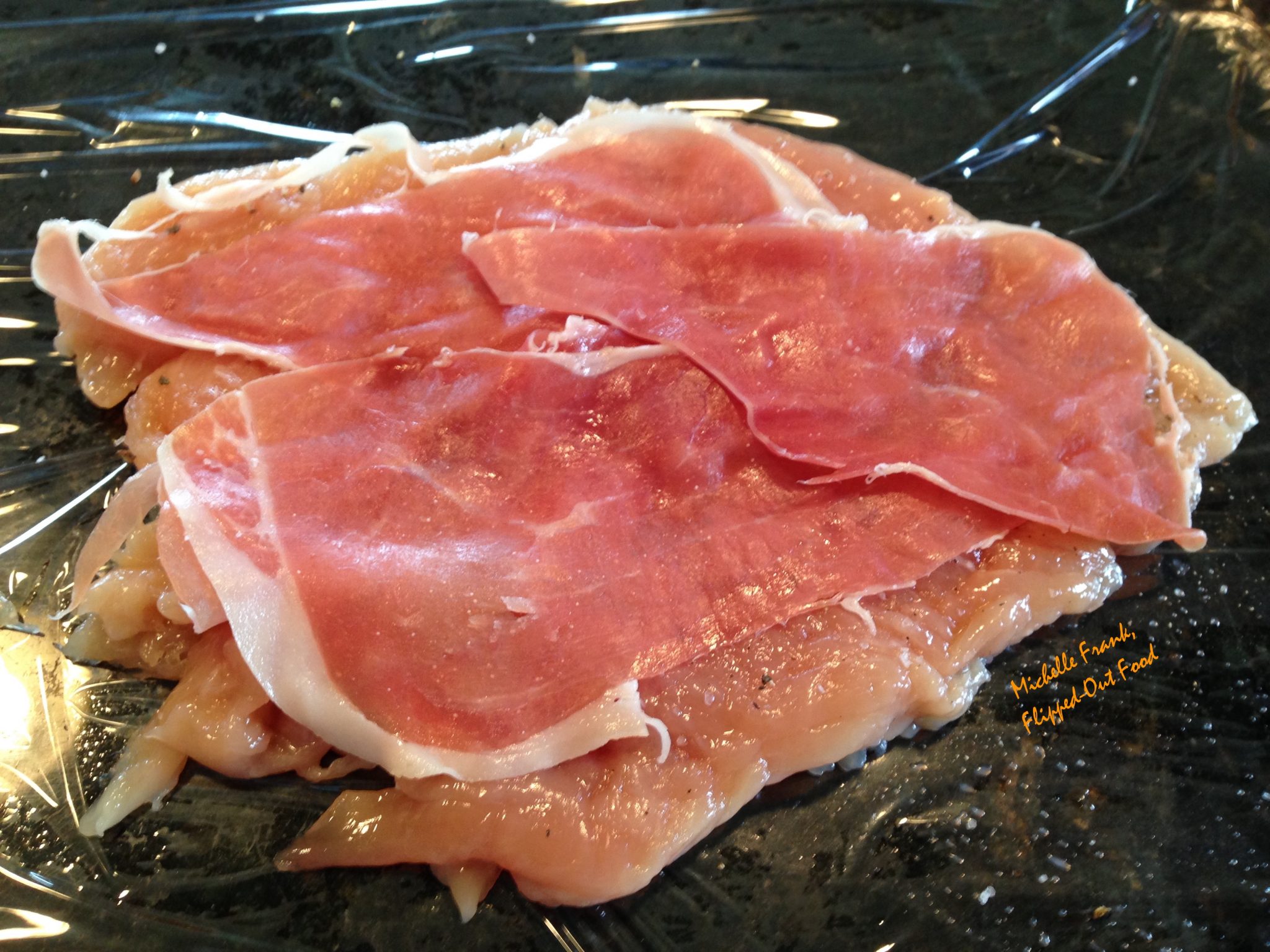 Arranging the prosciutto on the pounded out chicken breast for chicken rollatini.