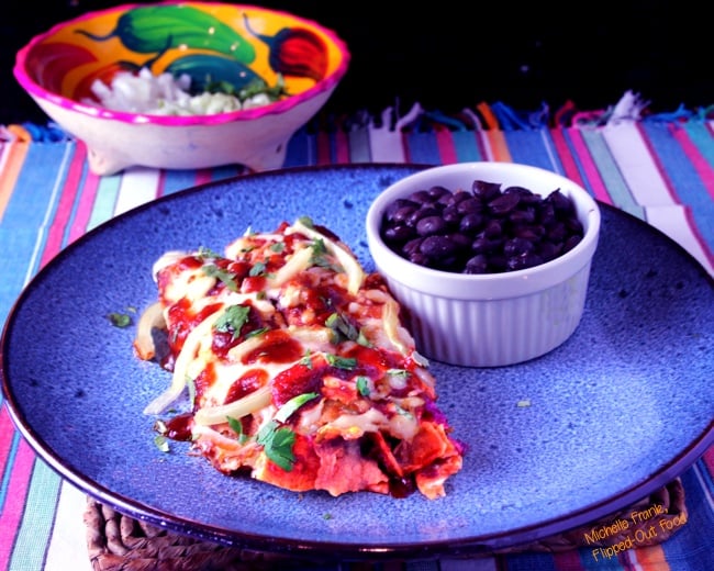 red enchiladas or chilaquiles serving with black beans