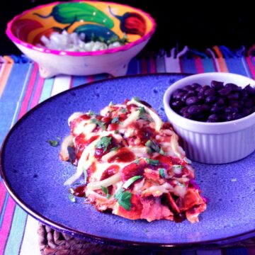 red enchiladas or chilaquiles serving with black beans