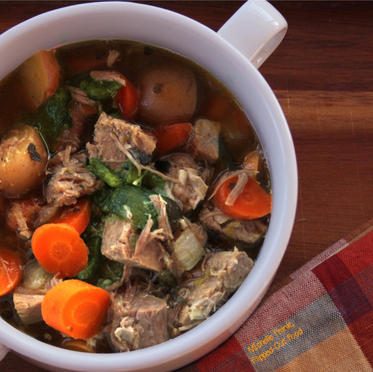 A closeup of Caldillo: Green Chile Pork Stew in a 2-handled bowl.