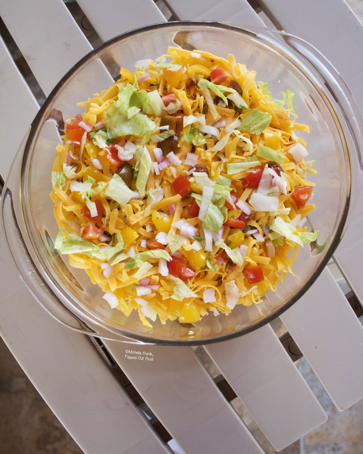 Phil's Taco Dip party appetizer in a clear pyrex serving dish.