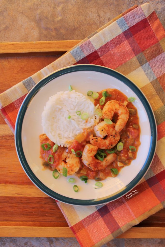 A single serving of my Make-Ahead Shrimp Etouffee recipe served with a mound of rice and garnished with sliced scallions.