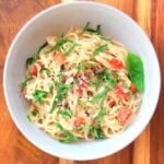 easy garlic-tomato-basil pasta serving on wood background