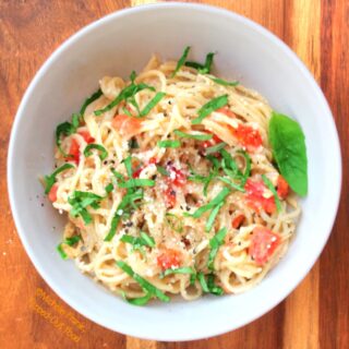 easy garlic-tomato-basil pasta serving on wood background