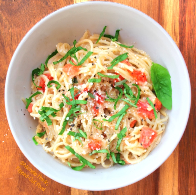 easy garlic-tomato-basil pasta serving on wood background