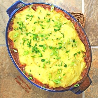 Guinness-Colcannon Shepherd Pie cooling in a blue casserole dish. A perfect Irish dish for Saint Patrick's Day and comfort food at its best. #saintpatricksday #stpaddysday #irishfood #comfortfood #shepherdspie #colcannon #guinness #lamb via @flippedoutfood