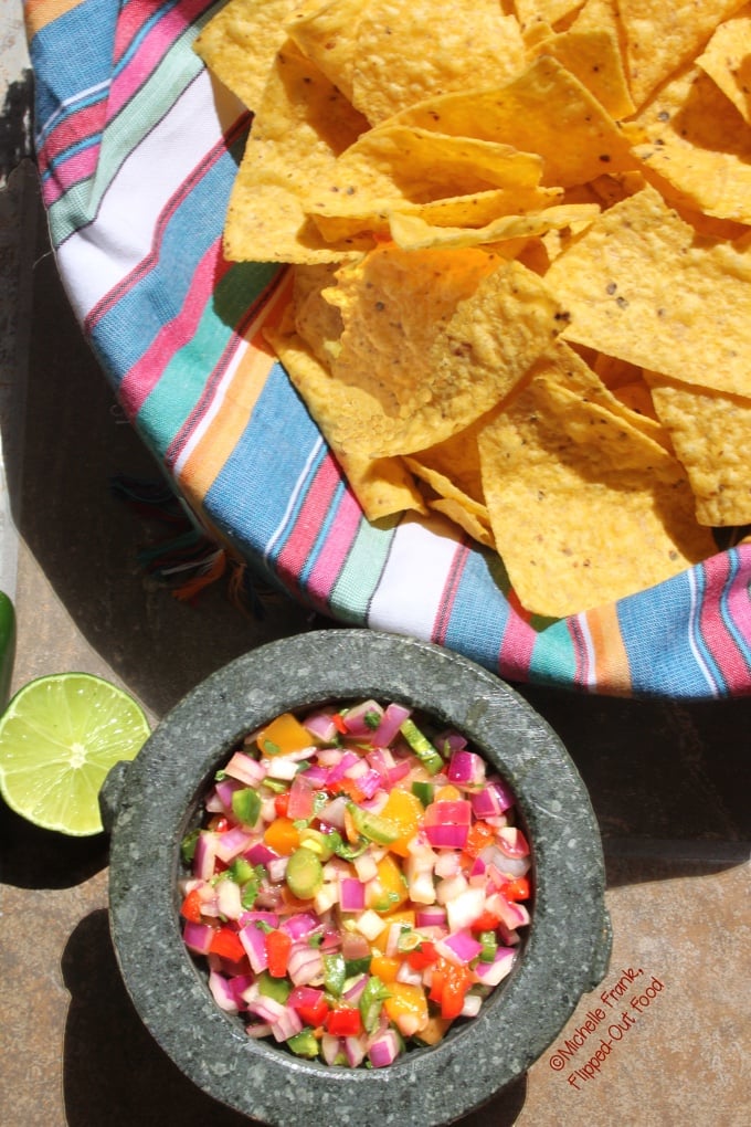 Virtual Memorial Day Potluck Recipe Roundup: Fiery Mango-Habanero Salsa in molcajete with tortilla chips and lime. #salsa #mexicanfood #partydip #spicyfood #flippedoutfood @FlippedOutFood