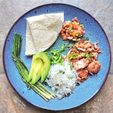 Slow-cooker mojo carnitas taco bar with mango-habanero salsa, warm tortilla, avocado, charred scallions, and rice. #mexicanfood #carnitas #slowcooker #crockpot #cincodemayo @FlippedOutFood