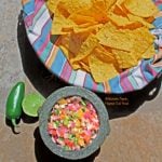 fiery mango-habanero salsa in molcajete with tortilla chips, lime, and jalapeno