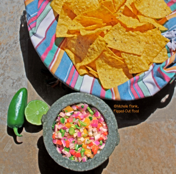 fiery mango-habanero salsa in molcajete with tortilla chips, lime, and jalapeno