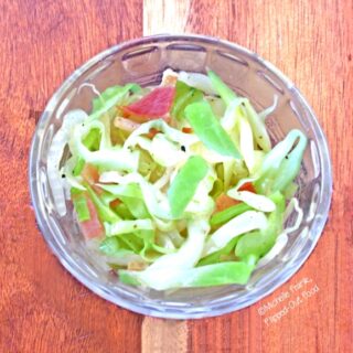 Piquant Cabbage-Onion-Bacon Saute in a clear ramekin. A delicious side dish for roasted meats—especially pork. #sauteedcabbage #friedcabbage #friedcabbageandbacon #bacon #cabbage #sidedish @FlippedOutFood