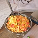 Dorm-Room Microwave Creamy Queso Spaghetti: close-up of a heaping serving amid piles of notes and geeky stuff.
