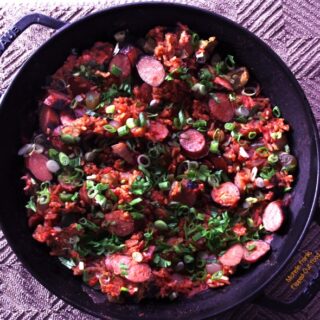 Cajun Sausage Rice Skillet, shown in the skillet, sprinkled with sliced scallions and parsley. Easy One-Pot Meal Recipes: Cajun Sausage-Rice Skillet