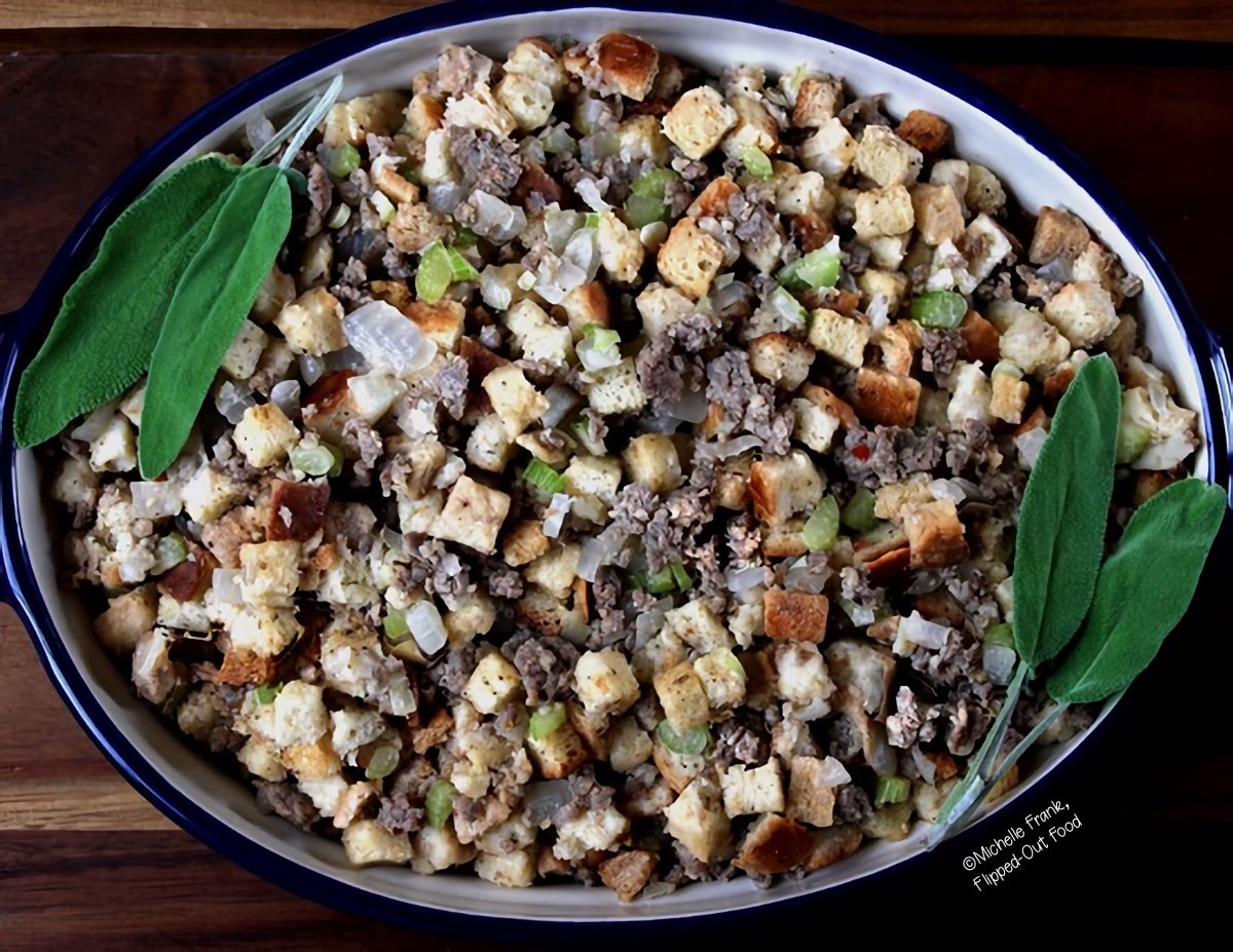 easy sausage stuffing in a ceramic baking dish, garnished with two sprigs of sage.