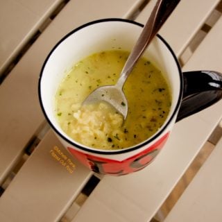 Pantry Creamy Chicken Ramen Soup in a large mug sitting atop a beige table.