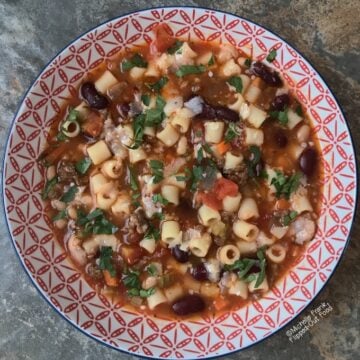 Pasta e Fagioli soup in a decorative red and white bowl.