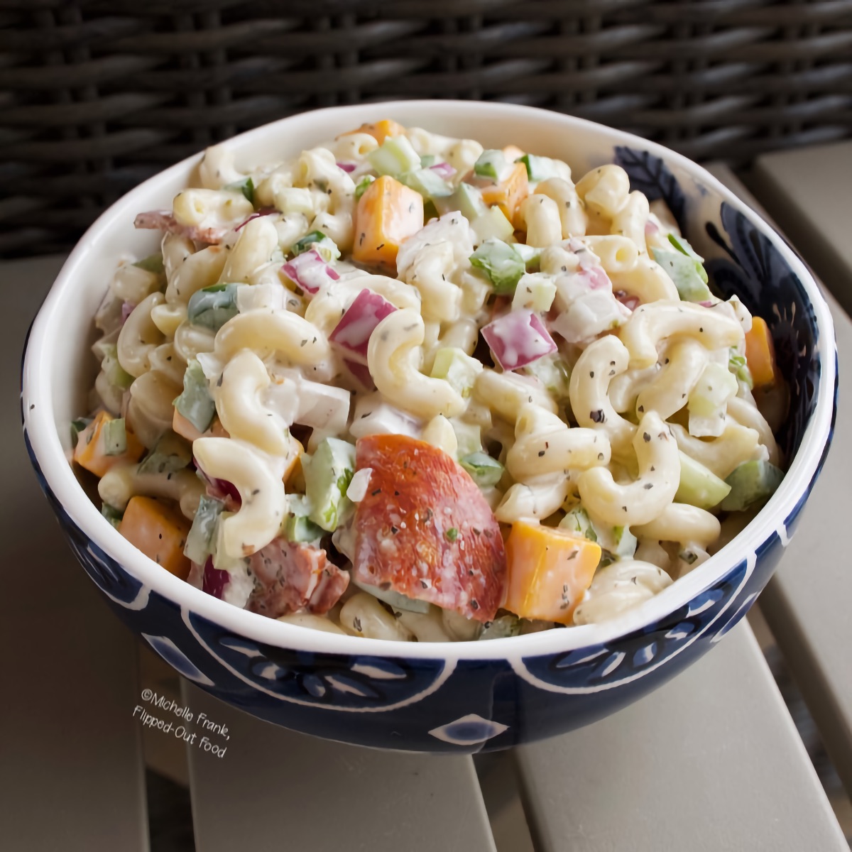 Top view of creamy pasta salad in a blue and white bowl.