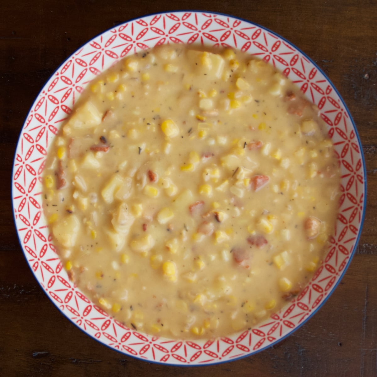 Cheesy Sweet Corn Chowder is creamy and delicious, with amazing sweet corn flavor because we start by simmering corn cobs in the broth. In the pictured bowl of chowder, you can see corn kernels, bits of bacon, and potatoes nestled in the creamy broth.