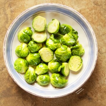 Easy Microwave Brussels Sprouts in a blue and white serving bowl.