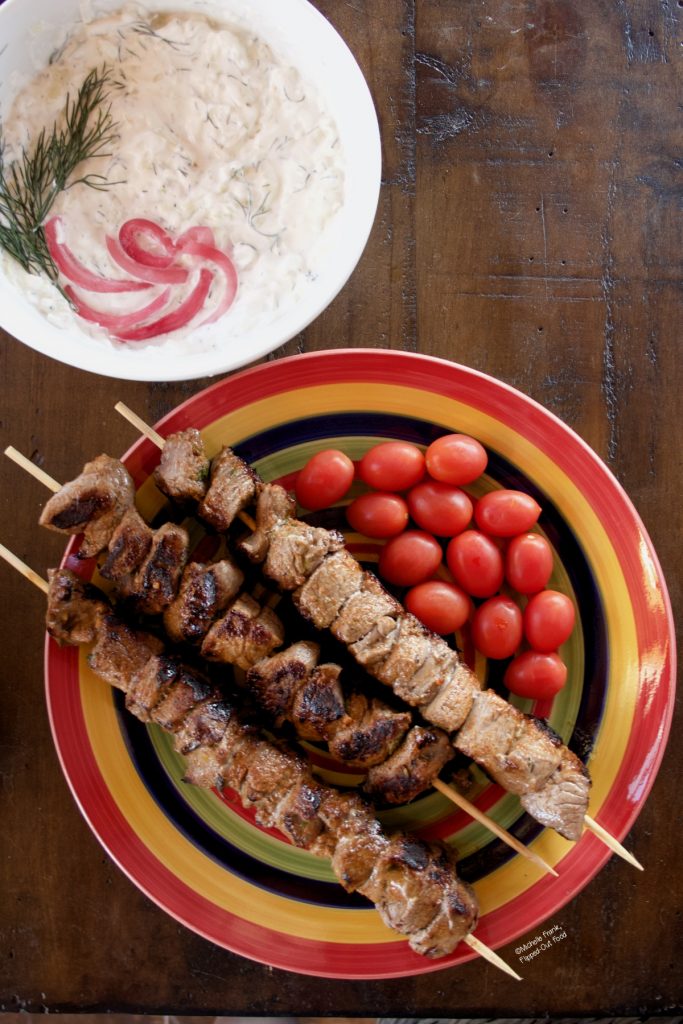 Grilled lamb kebabs served with grape tomatoes from the Farmbox, along with a tzatziki sauce made using the yellow onion and cucumber included in the shipment.