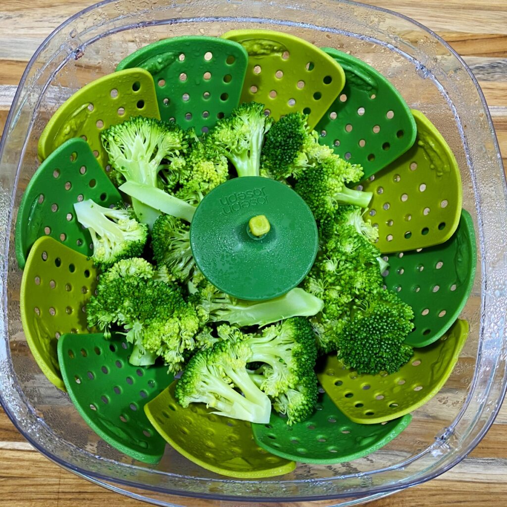 Easy Microwave Broccoli in the colander after being microwaved about 3 minutes. The color is beautiful, vibrant green and the broccoli is perfectly crisp-tender.