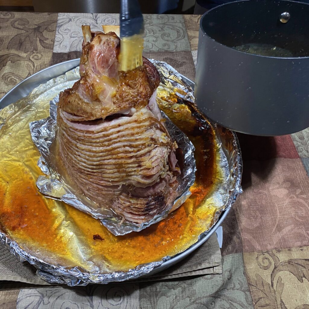 The ham is glazed a second time after unwrapping. Notice the pan juices still in the roasting pan (we've already removed most to a fat separator).