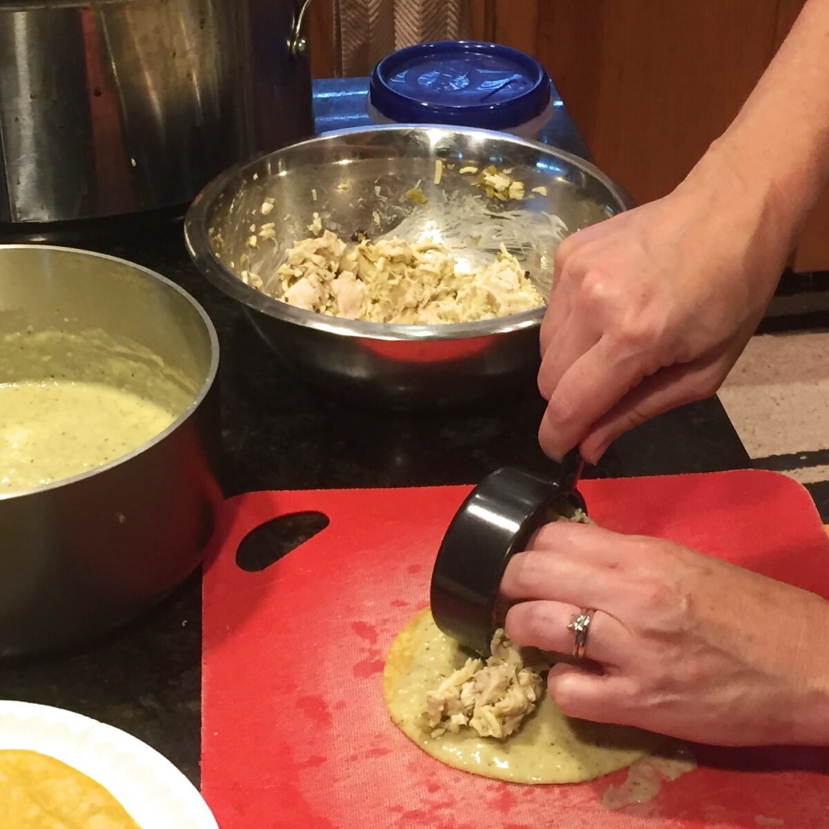 Adding enchilada filling to the sauce tortilla, ready for rolling.