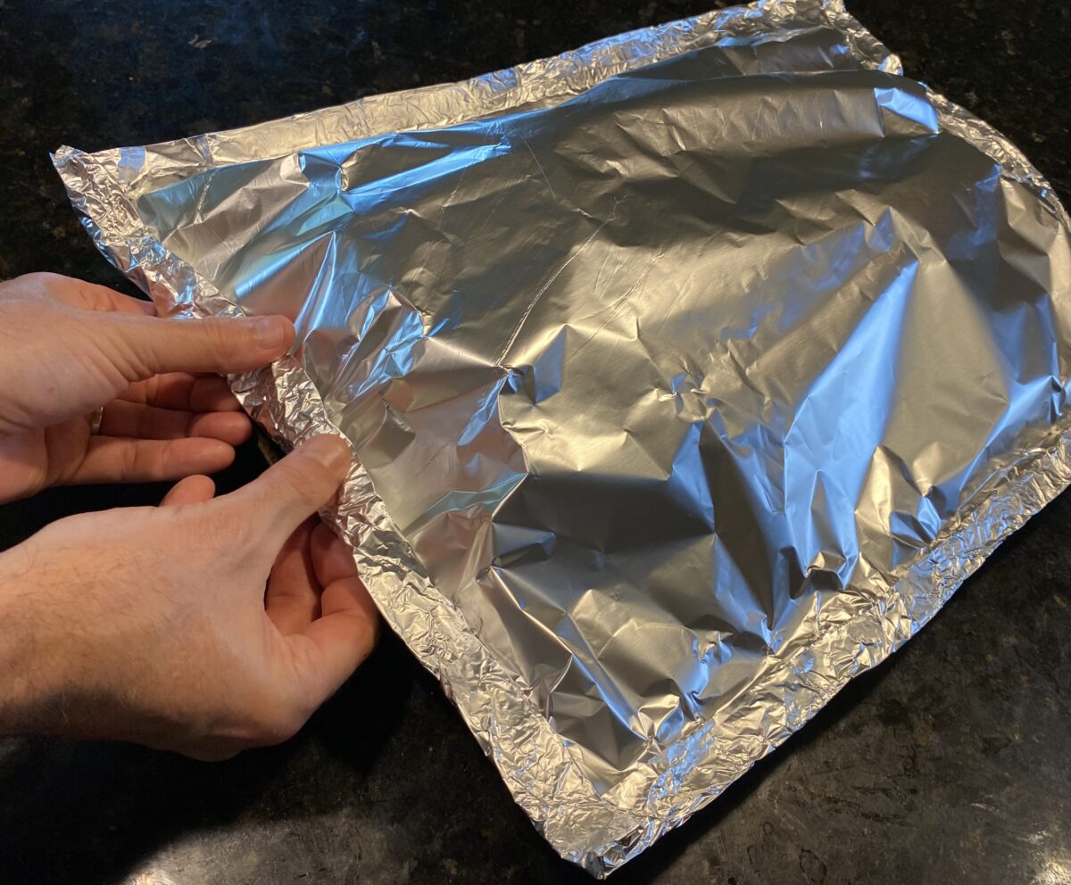 Side view showing how to fold the second tinfoil wrap with the first sheet creating a extremely tight seal locking in the steam once it starts cooking.