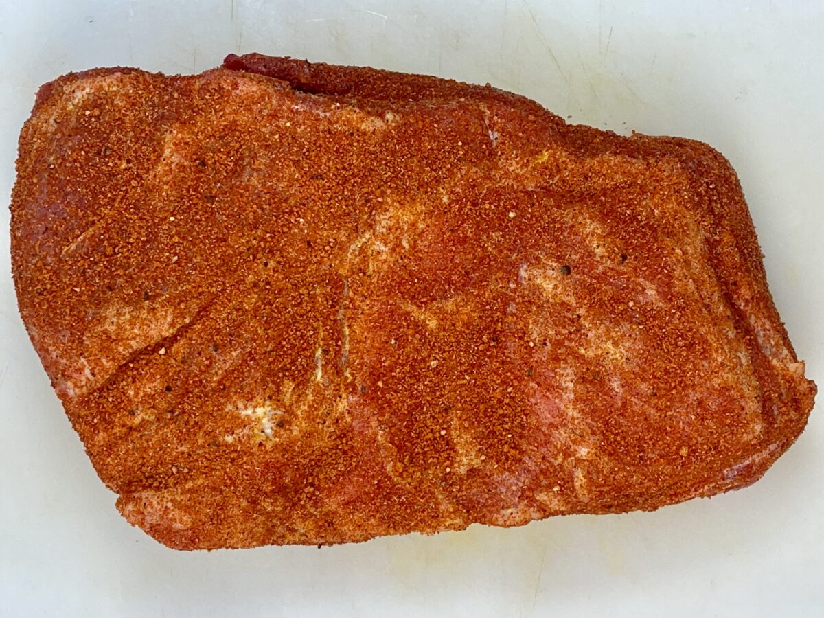 Top view of pork butt rubbed with pork butt rub, showing how much should be applied.