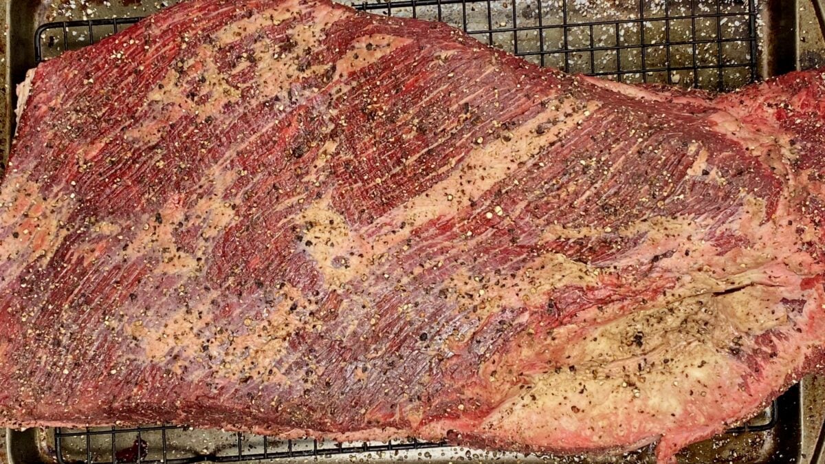 Top view of brisket that has been rubbed with salt, pepper and garlic powder.