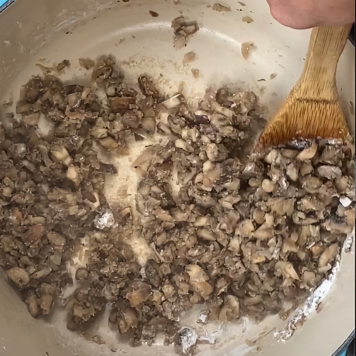Mixing the flour into the mushroom mixture and cooking the roux.