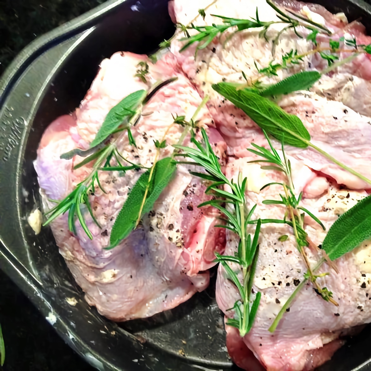 Turkey thighs topped with herbs and butter for extra drippings that will be used to make easy turkey gravy.