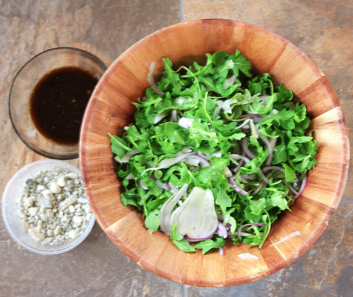 arugula-shaved fennel salad in wooden bowl