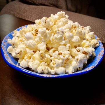 A bright blue bowl filled with freshly made Homemade Kettle Corn.