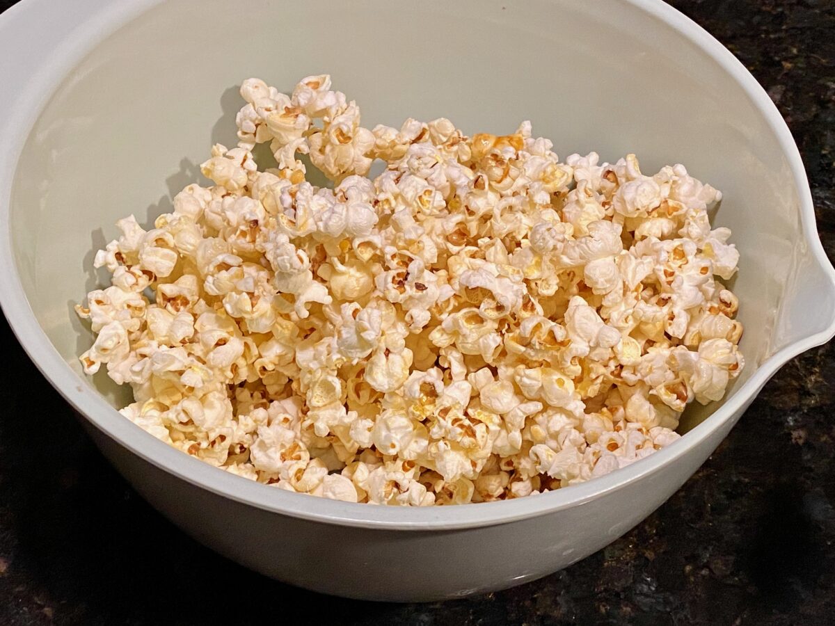 Top view of freshly made kettle corn in a large light green bowl.