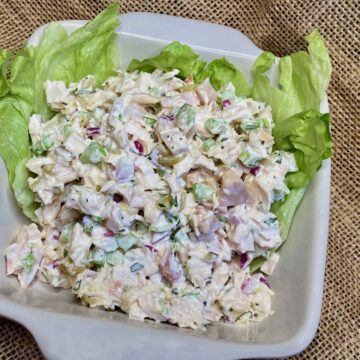 Chicken Salad with Relish on a bed of lettuce in a white dish.
