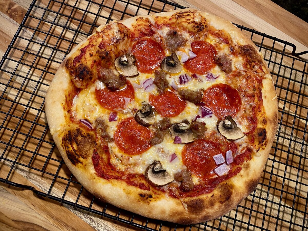 top view of a freshly baked pizza resting on a cooling rack.