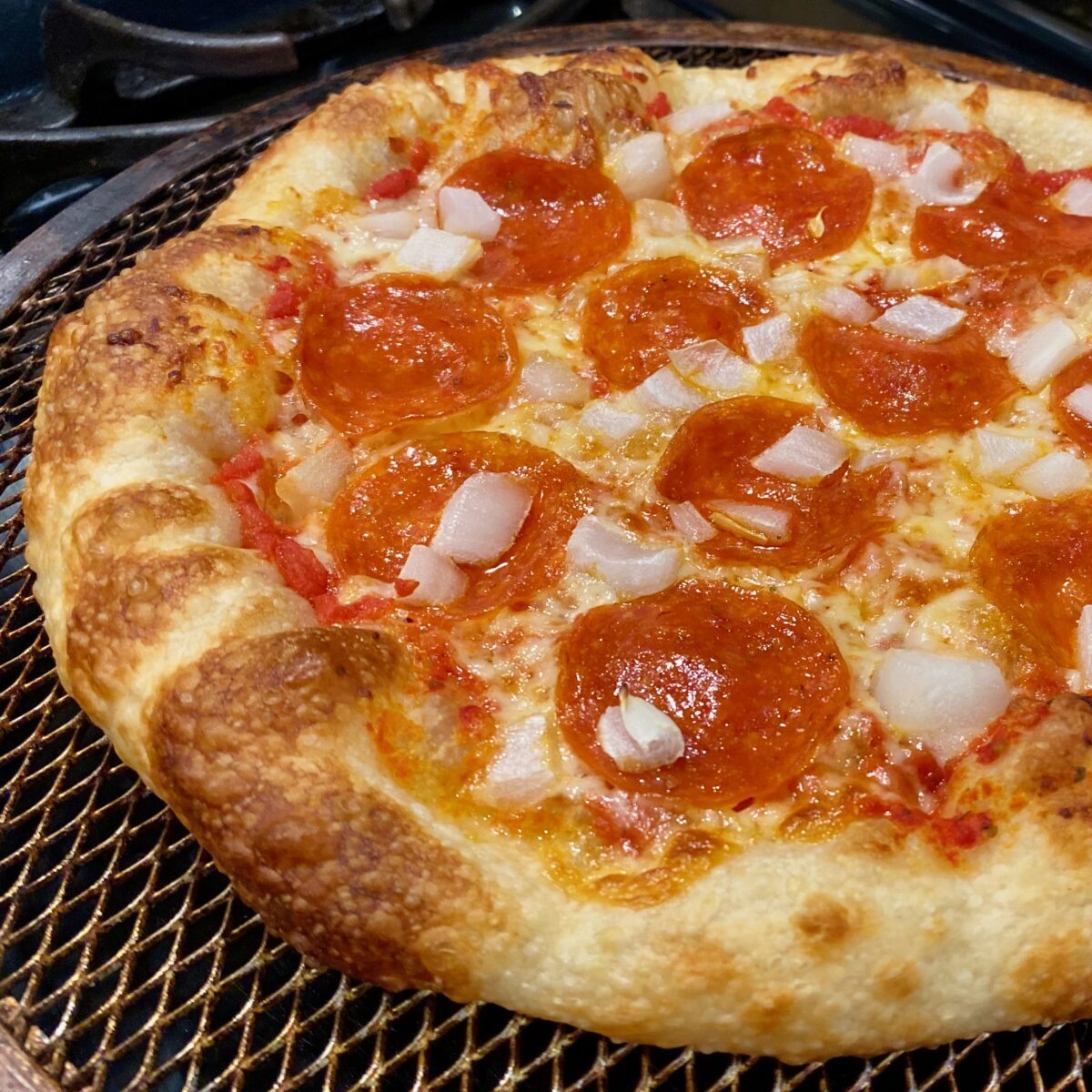 Close up view of pepperoni and onion pizza.