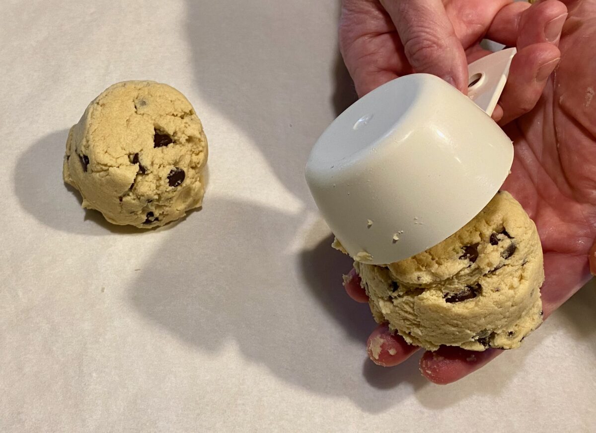 Portioning out ½-cup dough balls onto a parchment paper-lined baking sheet.