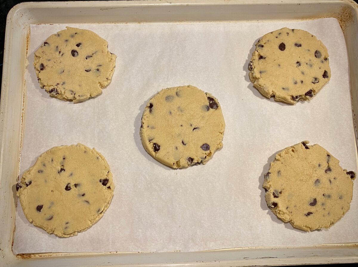 A tray of flattened cookies, ready to be covered and refrigerated.