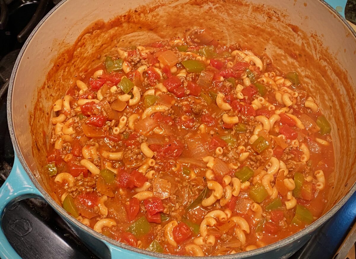 top view of american goulash in a blue pot on the stove.