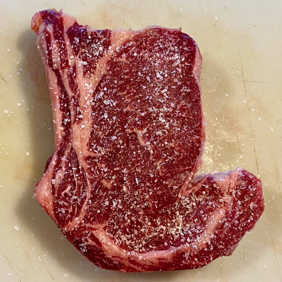 Top view of a ribeye that has been heavily salted.