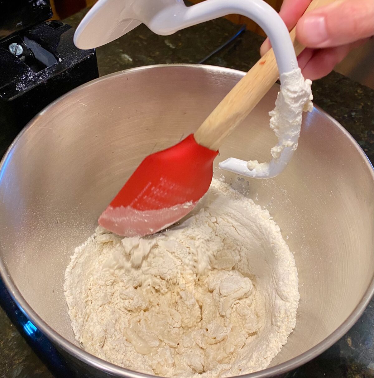 Scraping down the sides of the mixing bowl with a silicone spatula. 
