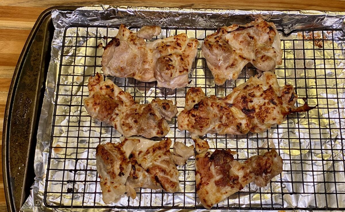 The chicken thighs have developed some char on one side after 8-10 minutes under the broiler. Now it's time to flip the chicken and char the other side.