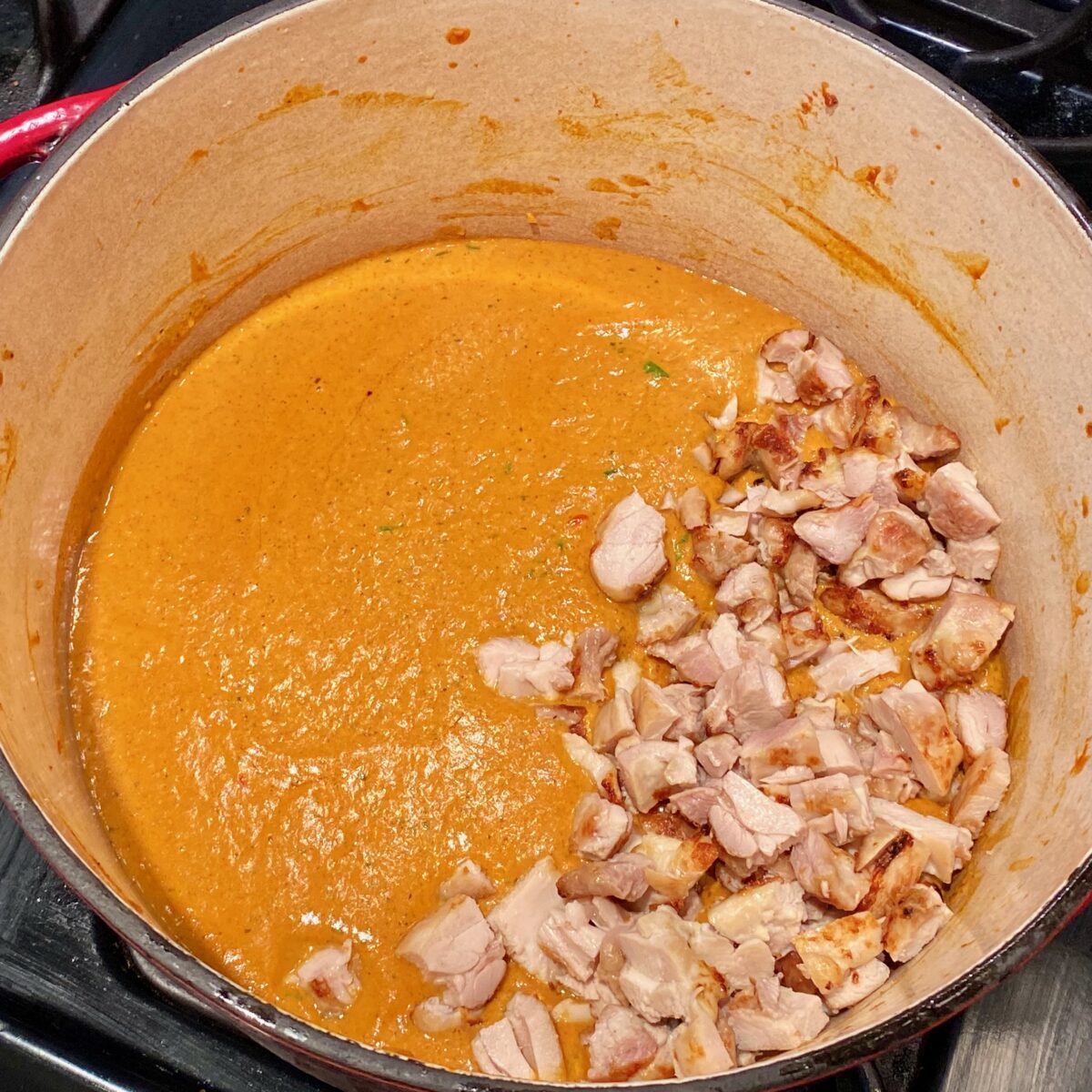 Adding the chicken to the butter sauce to warm through before serving.
