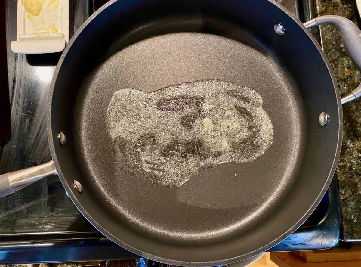 Melted butter in a pan, ready to add the first layer of bread.